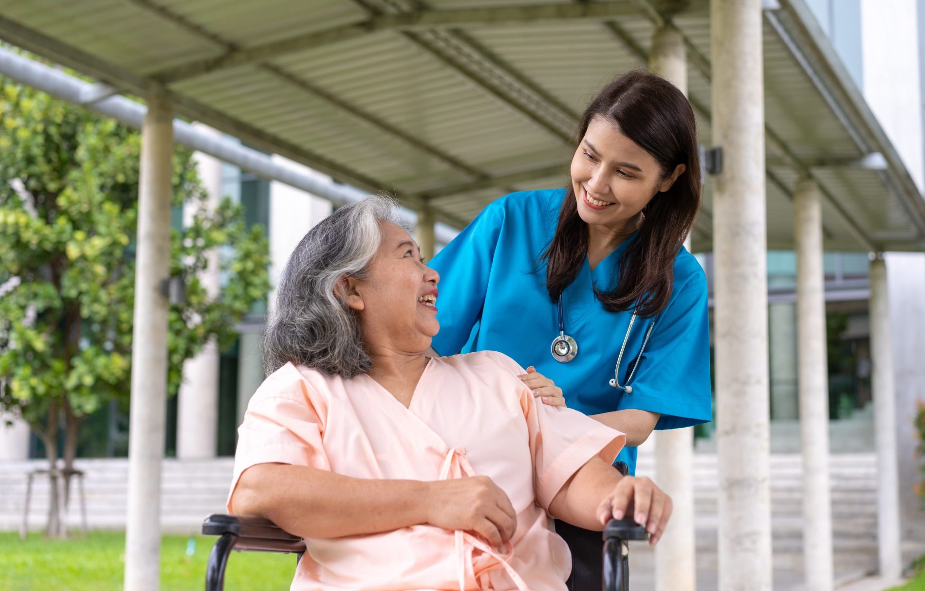A smiling nurse caring for an elderly woman at home in Bangalore
