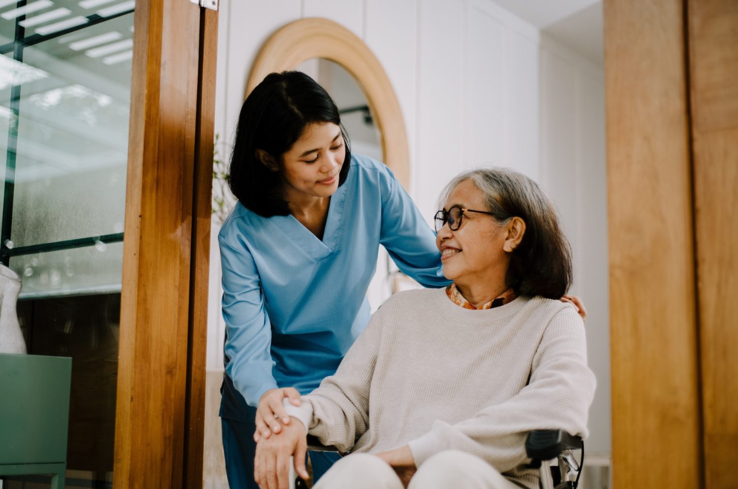 A caring nurse comforting an elderly woman at home